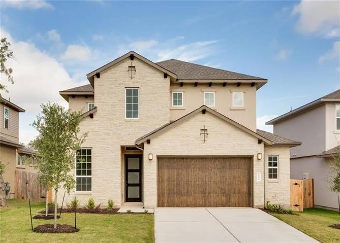 a view of a white house with a yard and potted plants