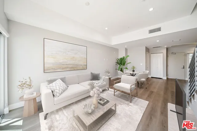 a living room with furniture wooden floor and a lamp