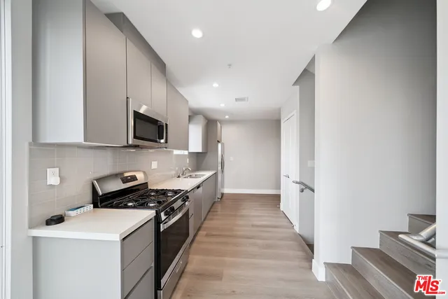 a kitchen with a sink appliances and cabinets