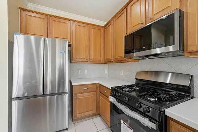 a kitchen with stainless steel appliances granite countertop a refrigerator stove and microwave