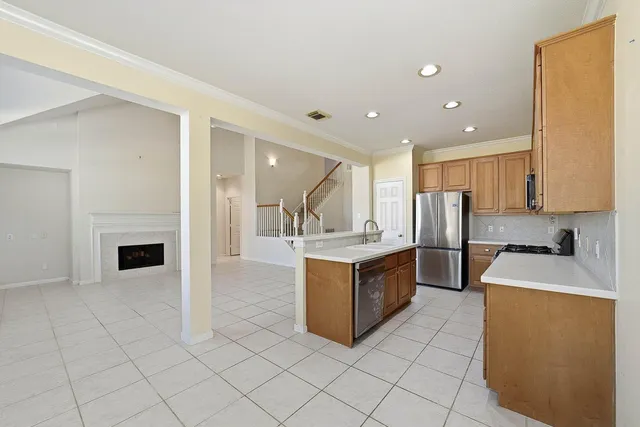 a kitchen with stainless steel appliances granite countertop a stove top oven a sink and a refrigerator