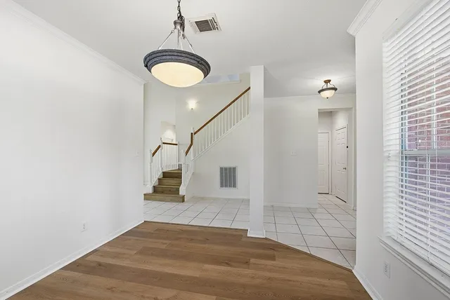 a view of a room with wooden floor and white walls