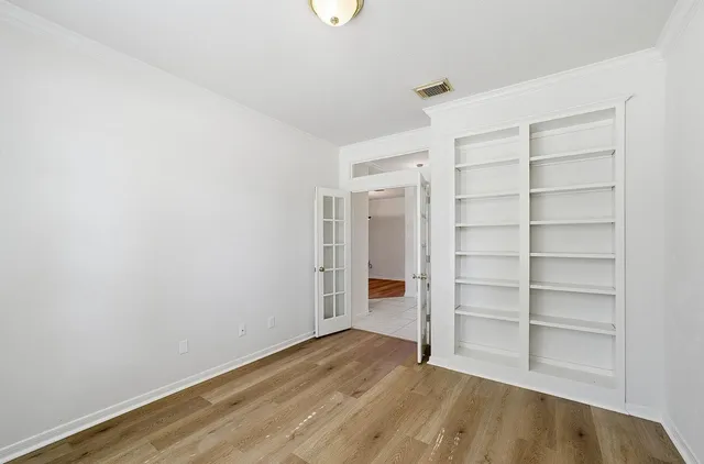 a view of empty room with wooden floor and closet