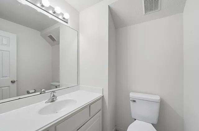 a bathroom with a toilet sink and mirror