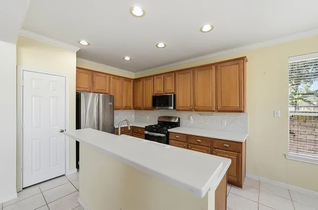 a kitchen with stainless steel appliances a refrigerator sink and microwave