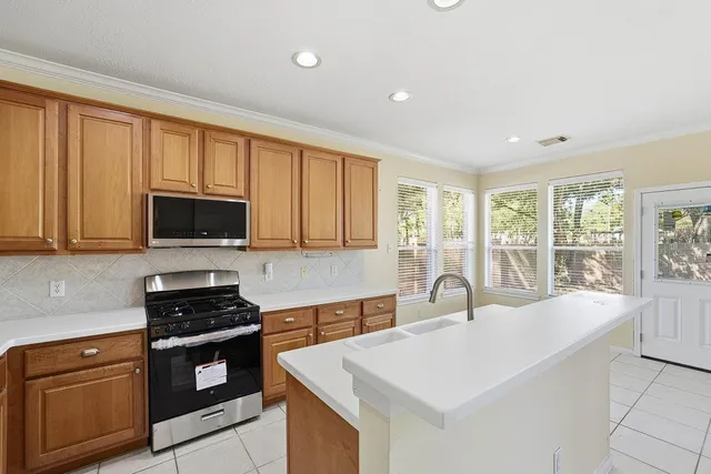 a kitchen with stainless steel appliances granite countertop a stove a sink and a microwave