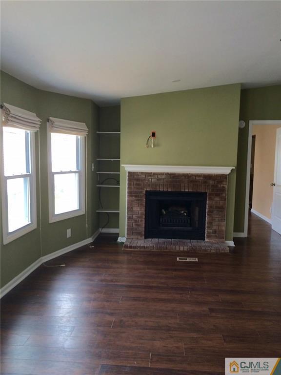 39 Poe Road, Unit 39 North Brunswick, NJ 08902 - Photo 5 of 21 an empty room with wooden floor a fireplace and windows