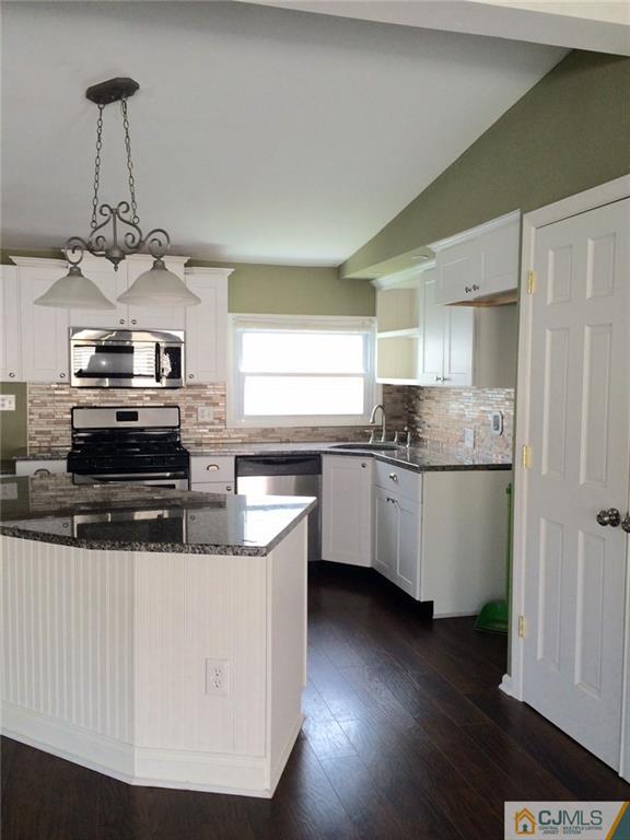39 Poe Road, Unit 39 North Brunswick, NJ 08902 - Photo 6 of 21 a kitchen with stainless steel appliances a sink a stove a refrigerator cabinets and a window