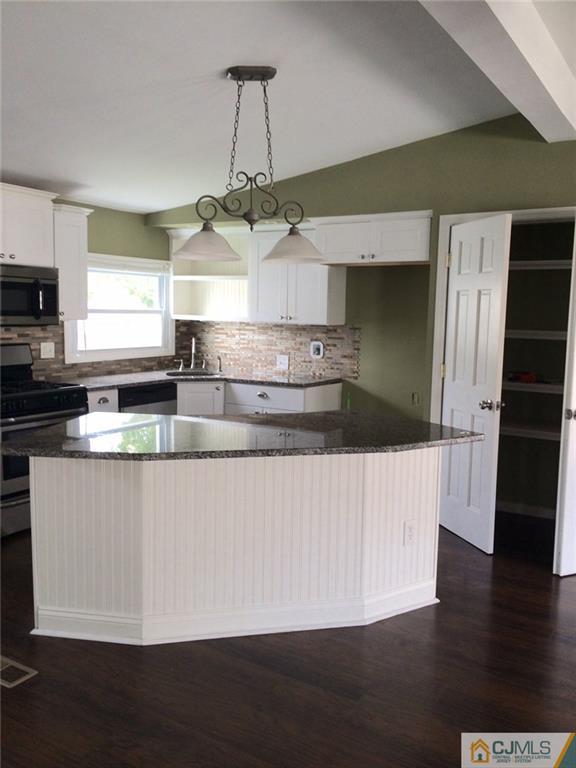 39 Poe Road, Unit 39 North Brunswick, NJ 08902 - Photo 7 of 21 a kitchen with stainless steel appliances granite countertop a refrigerator a sink a stove and a wooden floors