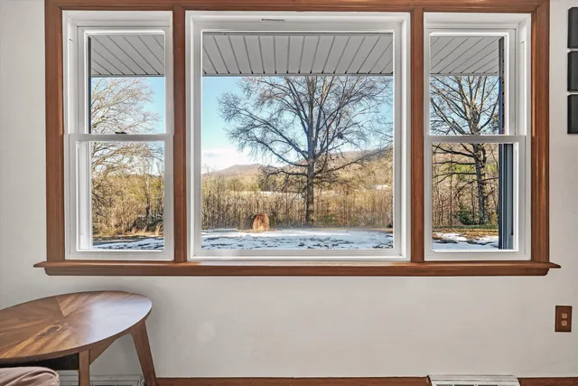 a view of a room that has a large window and a bed