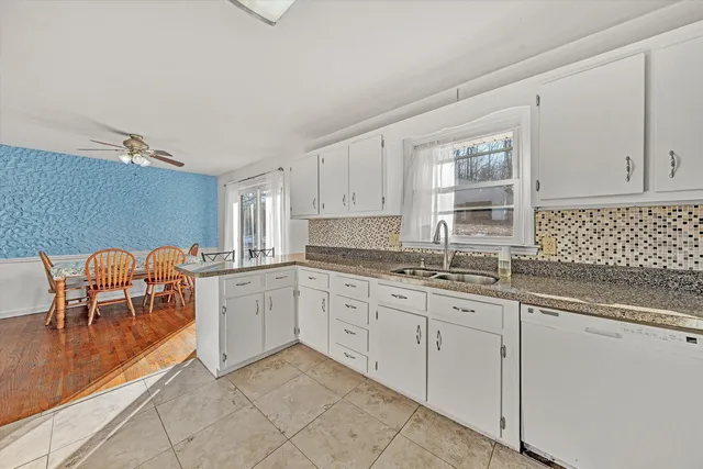 a kitchen with granite countertop white cabinets and white appliances