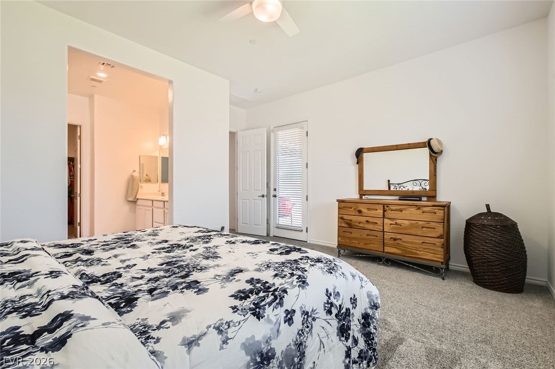 498 Pebble Run Avenue Henderson, NV 89011 - Photo 12 of 47 This spacious bedroom offers comfortable living with direct outdoor access and an adjacent private bathroom.