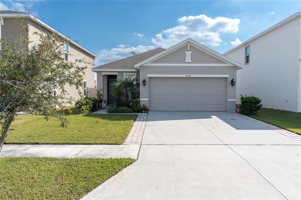 31130 Penny Surf Loop Wesley Chapel, FL 33545 - Photo 1 of 42 a front view of a house with a yard and garage