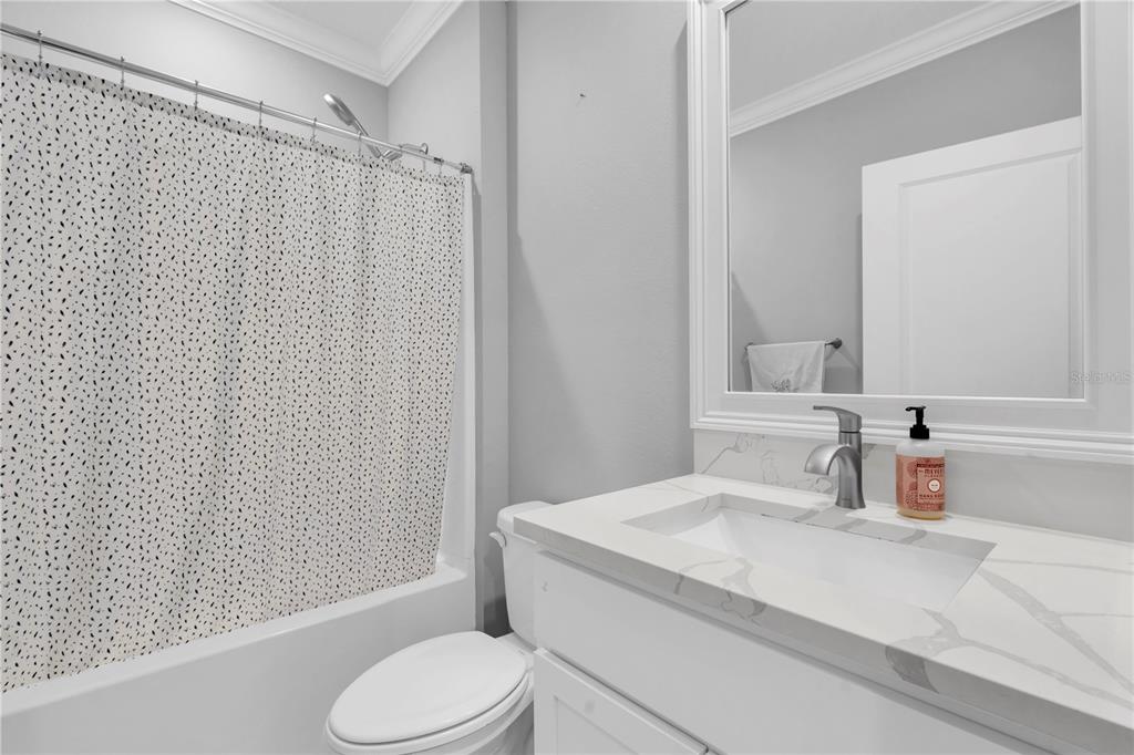 31130 Penny Surf Loop Wesley Chapel, FL 33545 - Photo 21 of 42 a bathroom with a granite countertop sink toilet and shower