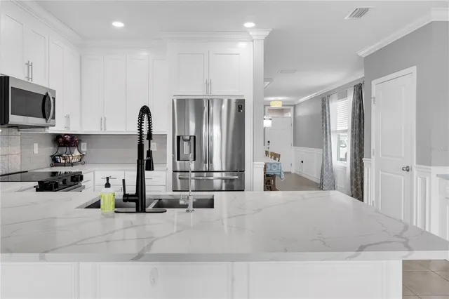 a large white kitchen with stainless steel appliances