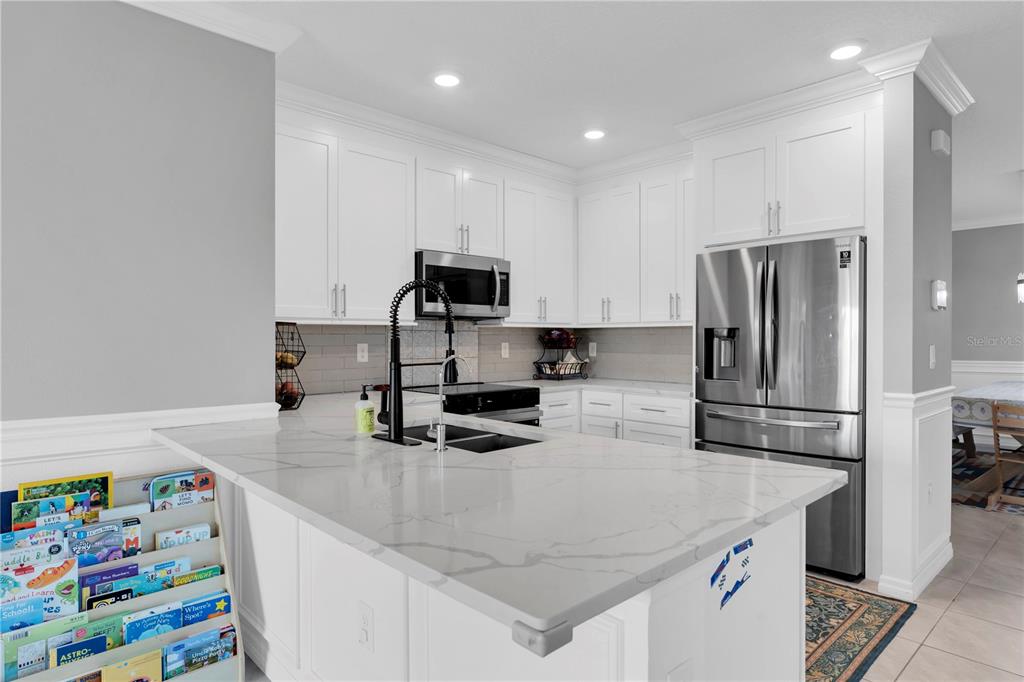 31130 Penny Surf Loop Wesley Chapel, FL 33545 - Photo 6 of 42 a kitchen with kitchen island a sink stove and refrigerator