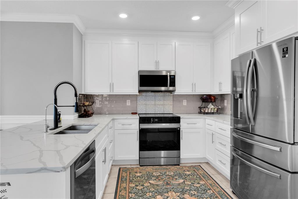 31130 Penny Surf Loop Wesley Chapel, FL 33545 - Photo 7 of 42 a kitchen with a refrigerator sink and cabinets