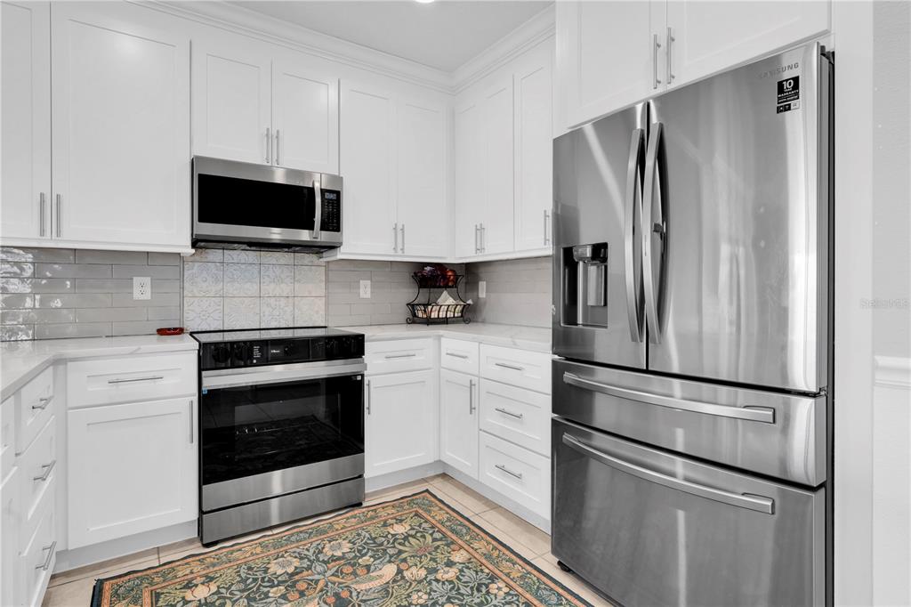 31130 Penny Surf Loop Wesley Chapel, FL 33545 - Photo 10 of 42 a kitchen with stainless steel appliances a refrigerator sink and microwave