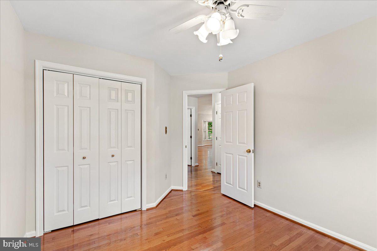 8307 Southstream Run Springfield, VA 22153 - Photo 13 of 49 an empty room with wooden floor chandelier fan and closet area