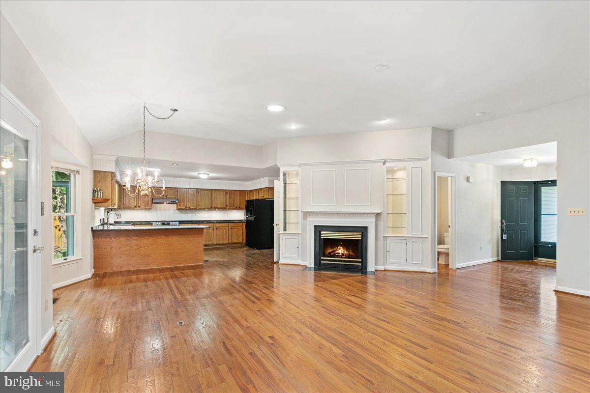 8307 Southstream Run Springfield, VA 22153 - Photo 19 of 49 a large kitchen with a wooden floor and a fireplace