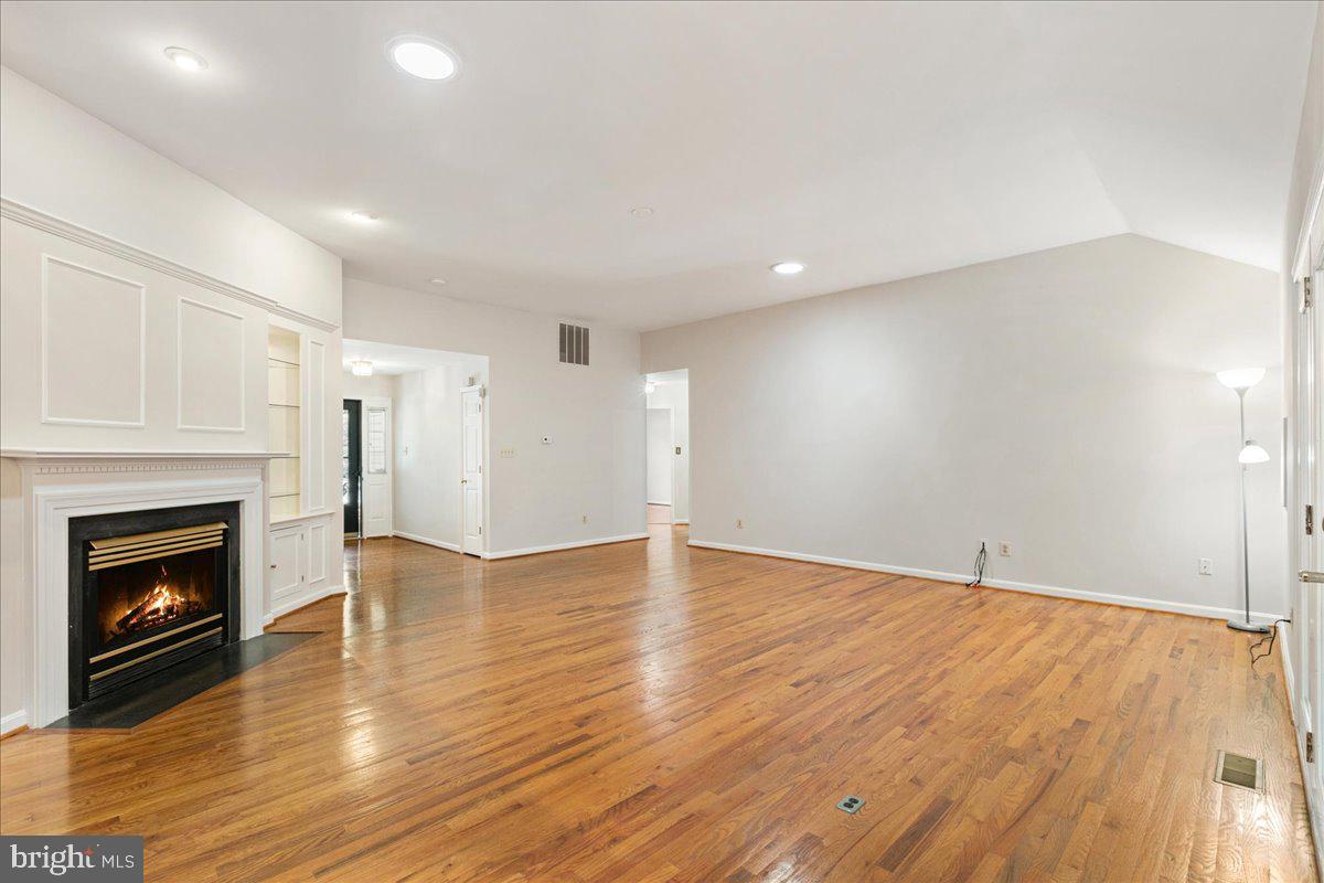 8307 Southstream Run Springfield, VA 22153 - Photo 20 of 49 a view of an empty room with wooden floor fireplace and a window