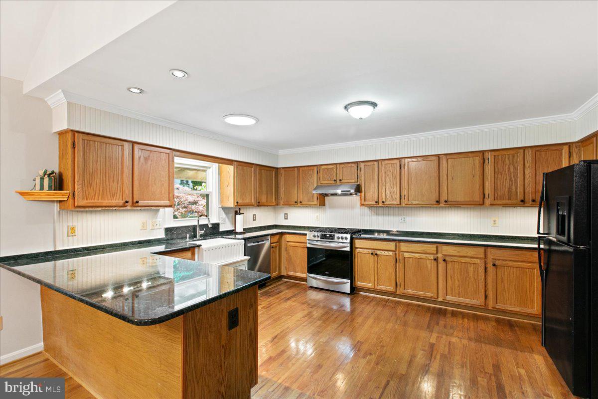 8307 Southstream Run Springfield, VA 22153 - Photo 23 of 49 a kitchen with stainless steel appliances granite countertop a sink stove and refrigerator