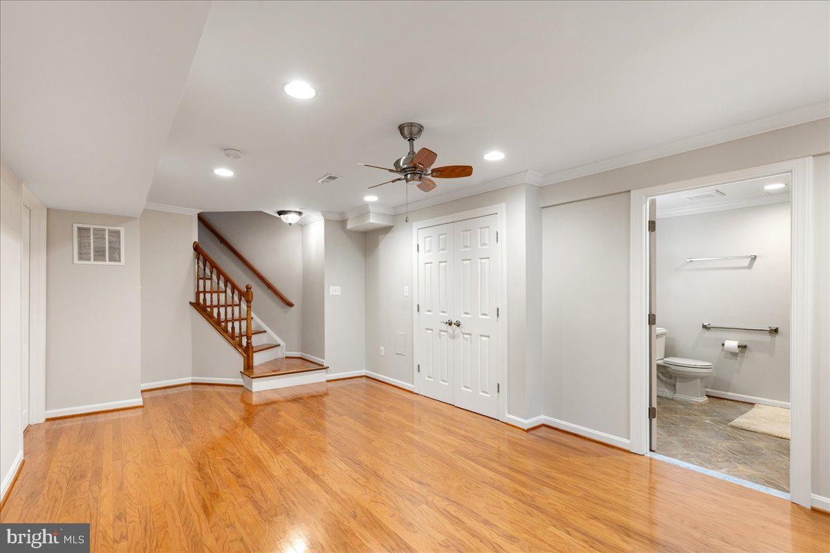 8307 Southstream Run Springfield, VA 22153 - Photo 30 of 49 a view of a room with wooden floor and a ceiling fan