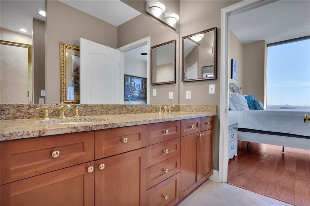 2828 Peachtree Road Northwest, Unit 1901 Atlanta, GA 30305 - Photo 22 of 35 a bathroom with a granite countertop sink and a mirror