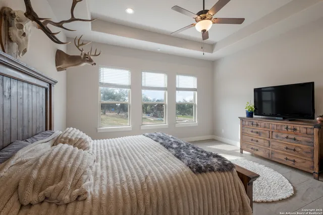 a bedroom with a bed a chandelier and a flat screen tv
