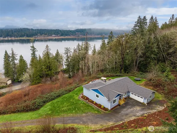an aerial view of a house with a yard and lake view