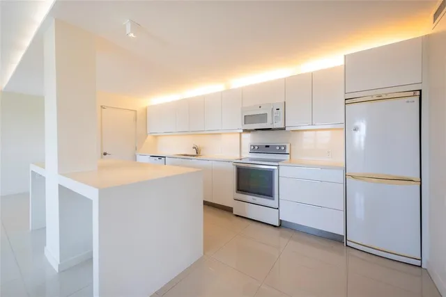 a kitchen with white cabinets and white appliances