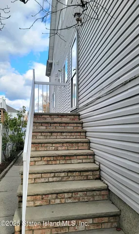 a room with stainless steel appliances dining table a rug a rug and a window