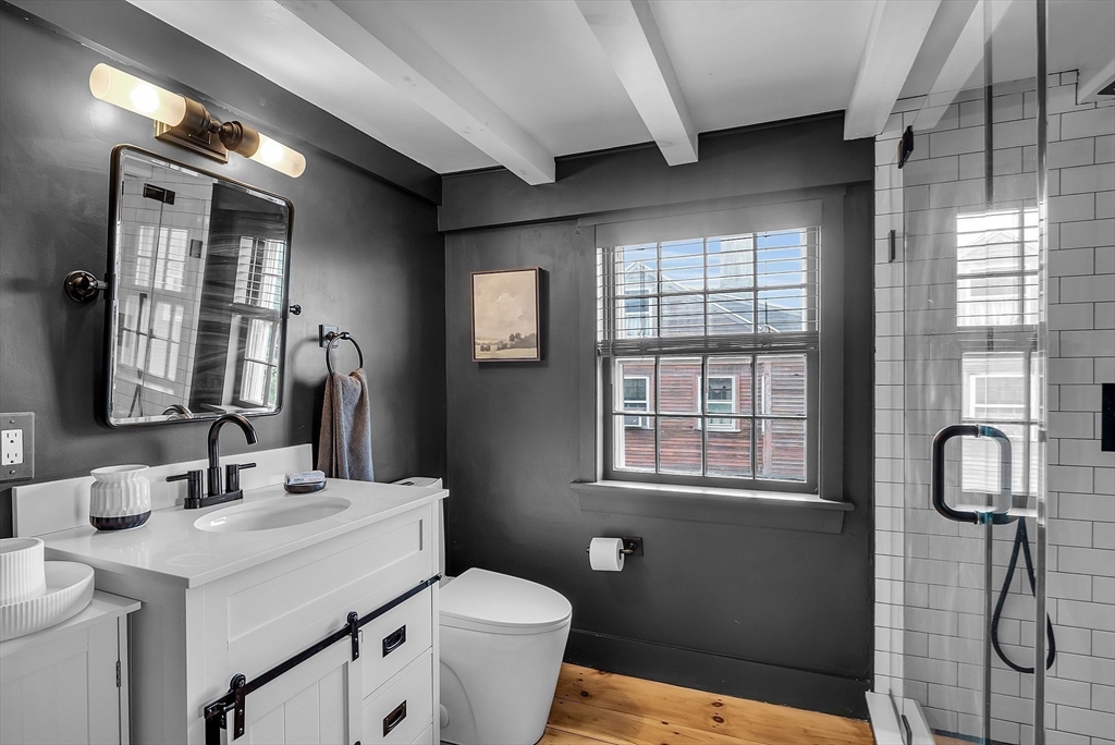 16 River Street Salem, MA 01970 - Photo 26 of 37 a bathroom with a toilet a sink and mirror