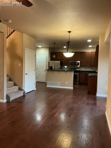 a kitchen with a chandelier and wooden floor