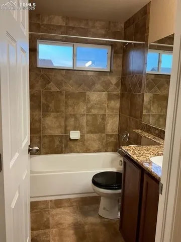 a bathroom with a granite countertop bathtub shower sink and toilet