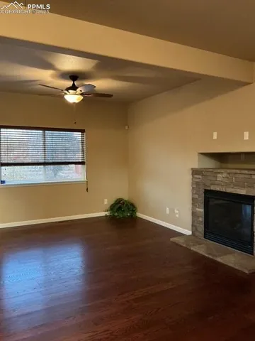 a view of a room with wooden floor a fireplace and window