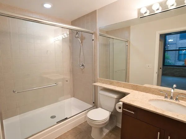 a bathroom with a sink a toilet and shower