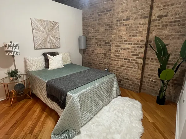 a bedroom with a bed and a potted plant