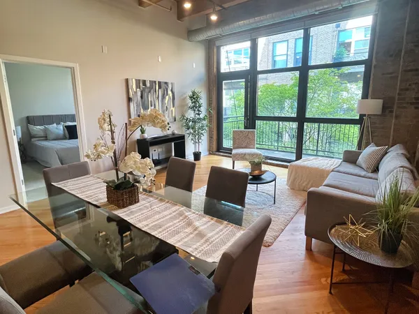 a living room with furniture fireplace and a large window