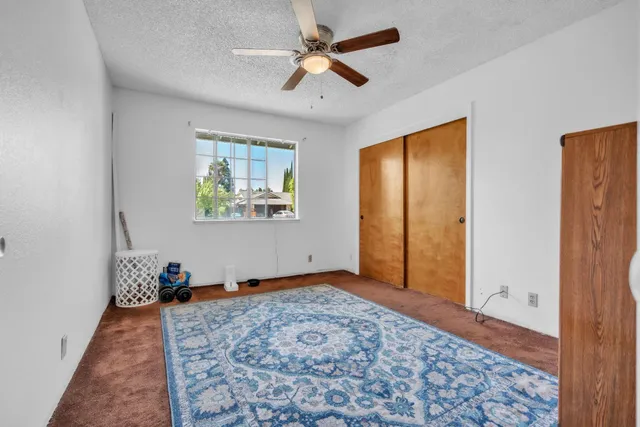 wooden floor in a livingroom with a window and a rug