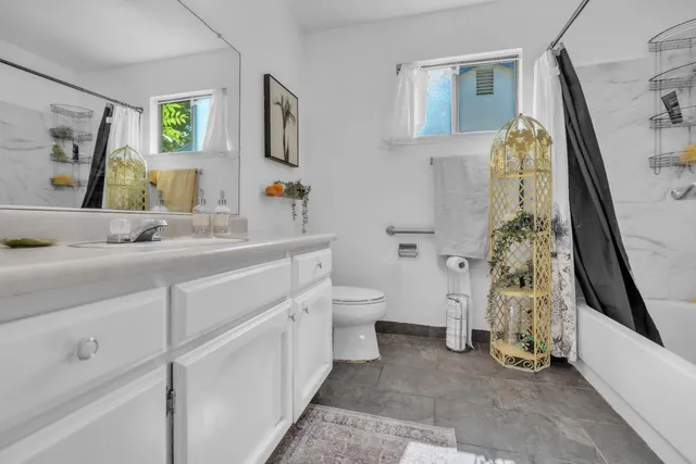 a bathroom with a sink a toilet and a mirror