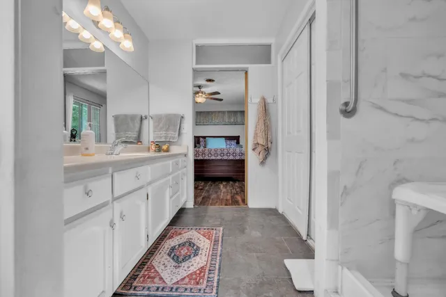 a large bathroom with a double vanity sink a toilet and a shower