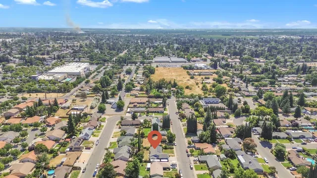 aerial view of a house with a yard and large tree