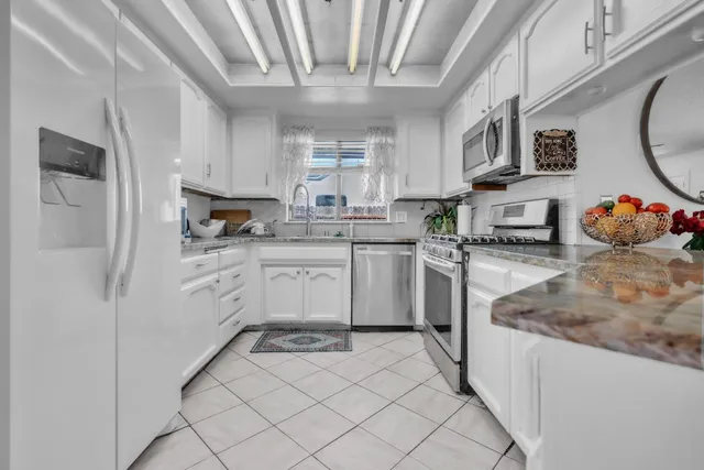 a kitchen with stainless steel appliances granite countertop a sink and cabinets
