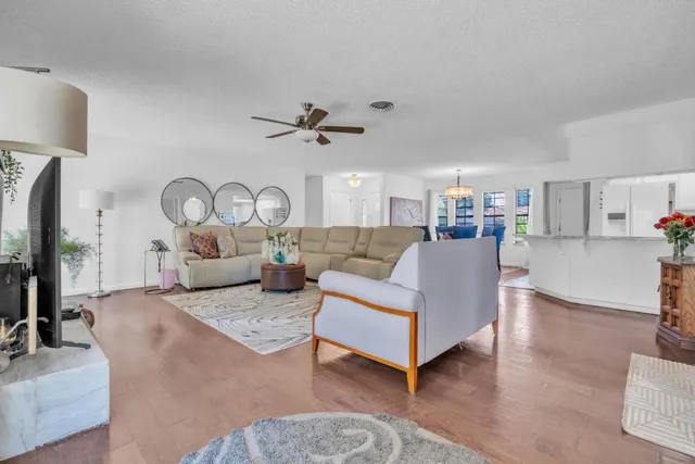 a living room with furniture white walls and a flat screen tv