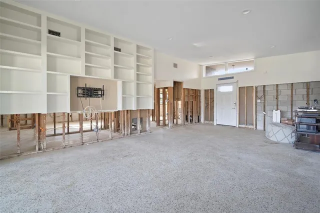 a view of an empty room with floor to ceiling window and stairs