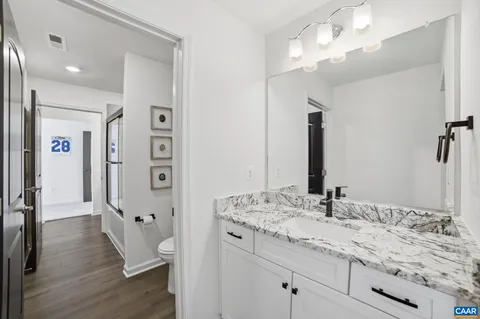 a bathroom with a granite countertop sink a mirror and shower