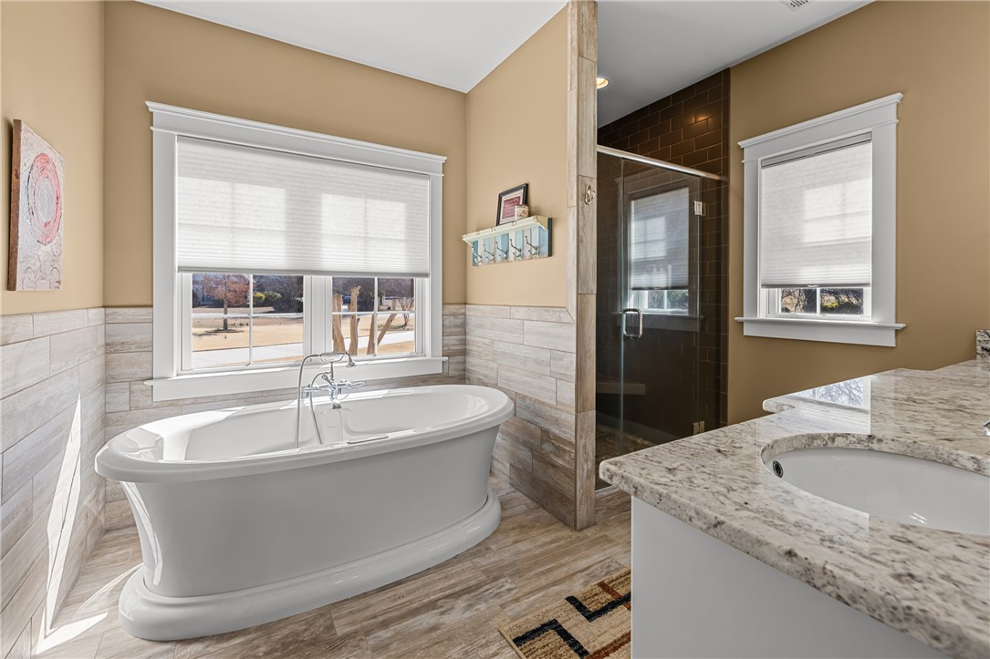 209 Crestridge Drive Seneca, SC 29672 - Photo 23 of 49 This serene bathroom offers a luxurious soaking tub, a spacious shower, and elegant granite vanity.