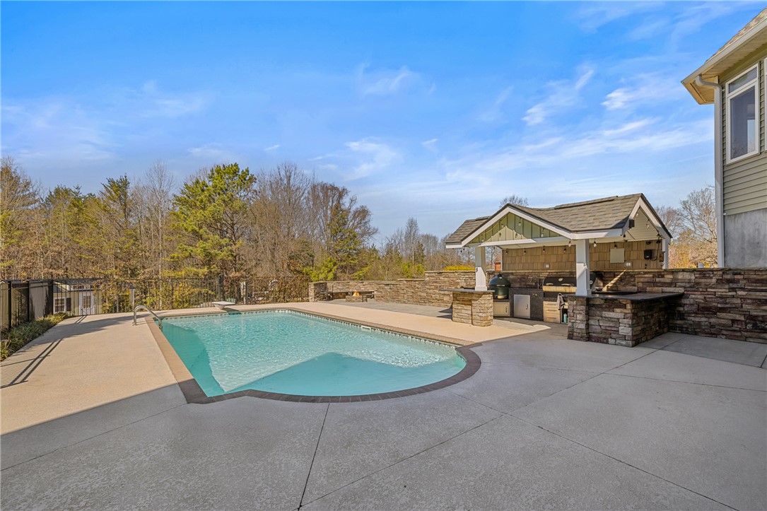 209 Crestridge Drive Seneca, SC 29672 - Photo 41 of 49 An inviting backyard oasis features a sparkling pool and a custom outdoor kitchen.