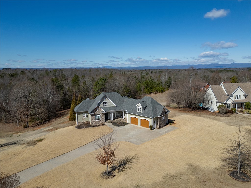 209 Crestridge Drive Seneca, SC 29672 - Photo 45 of 49 An aerial view showcases a residence with a sprawling driveway, surrounded by natural landscapes.